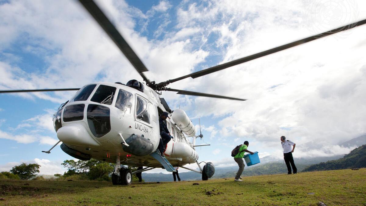 Timor-Leste Holds Second Round of Presidential Election A helicopter with a person walking away from the open door holding a blue box.