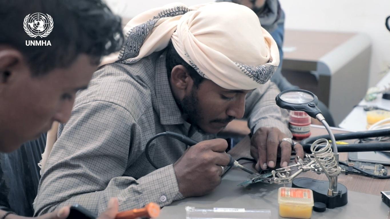 A man receives training in mobile phone repair